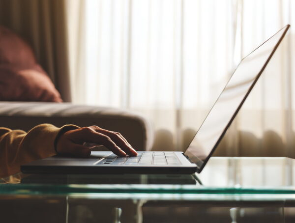 Person completing an online San Diego bail bonds application on a laptop from home for fast and convenient bail bond approval.